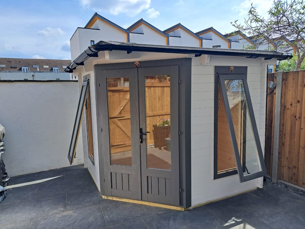 Freshly painted garden shed in a sleek grey finish.
