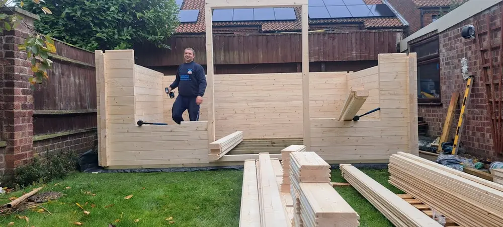 Radek assembling a log cabin
