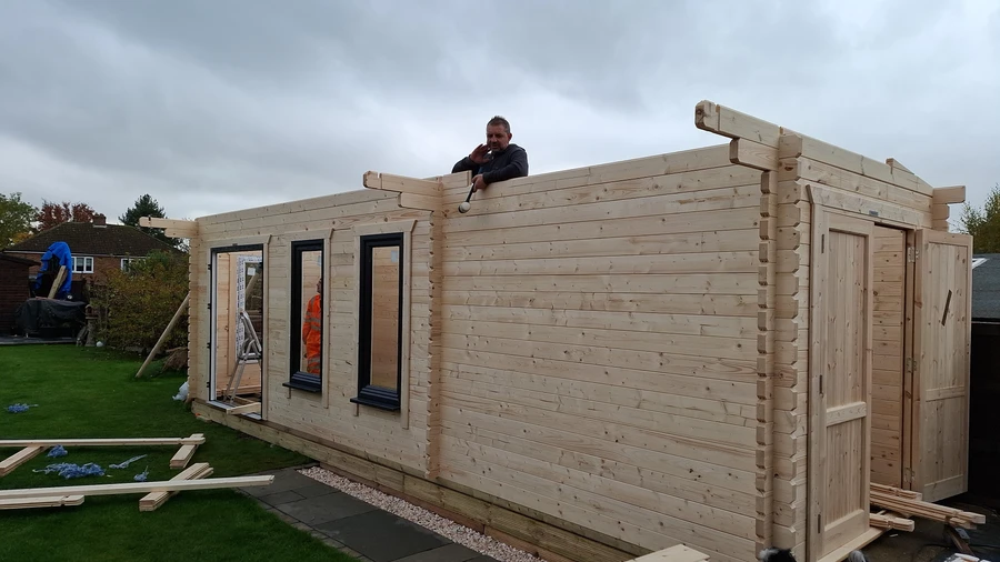 log cabin installation process, one of our team members installing cabin roof